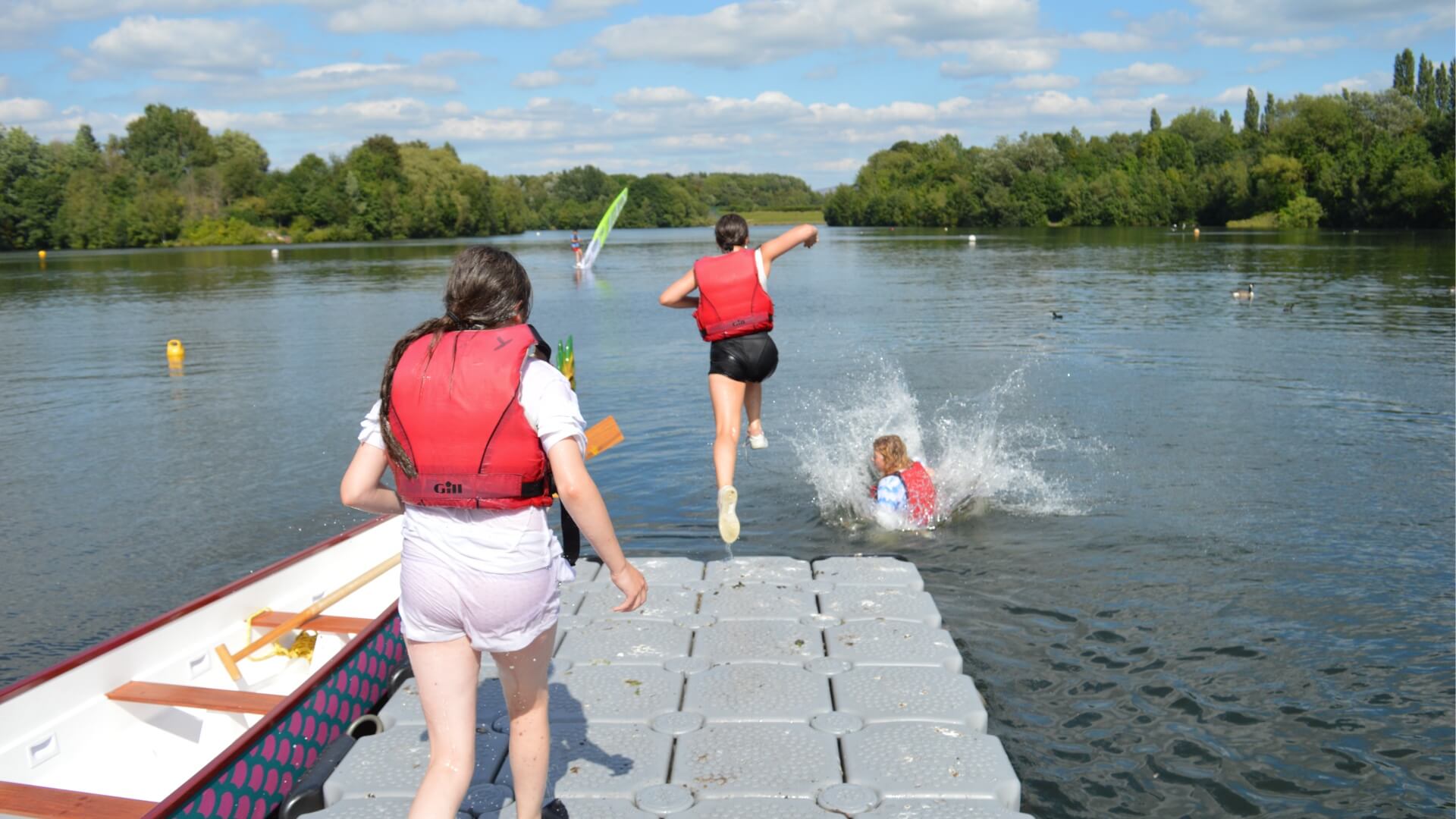 Supervised children jumping into a lake