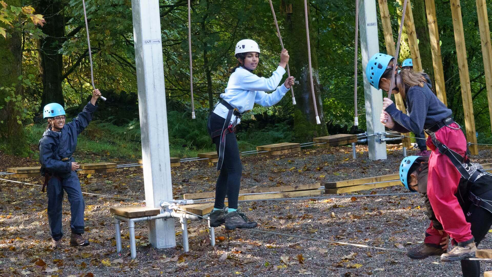 Members climbing on the ropes course